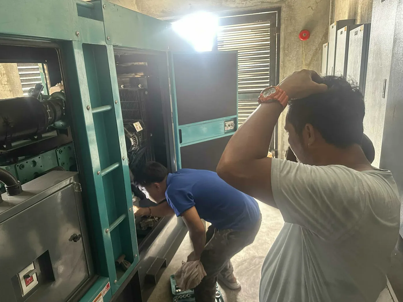 Wattsavers technicians servicing an enclosed standby generator set