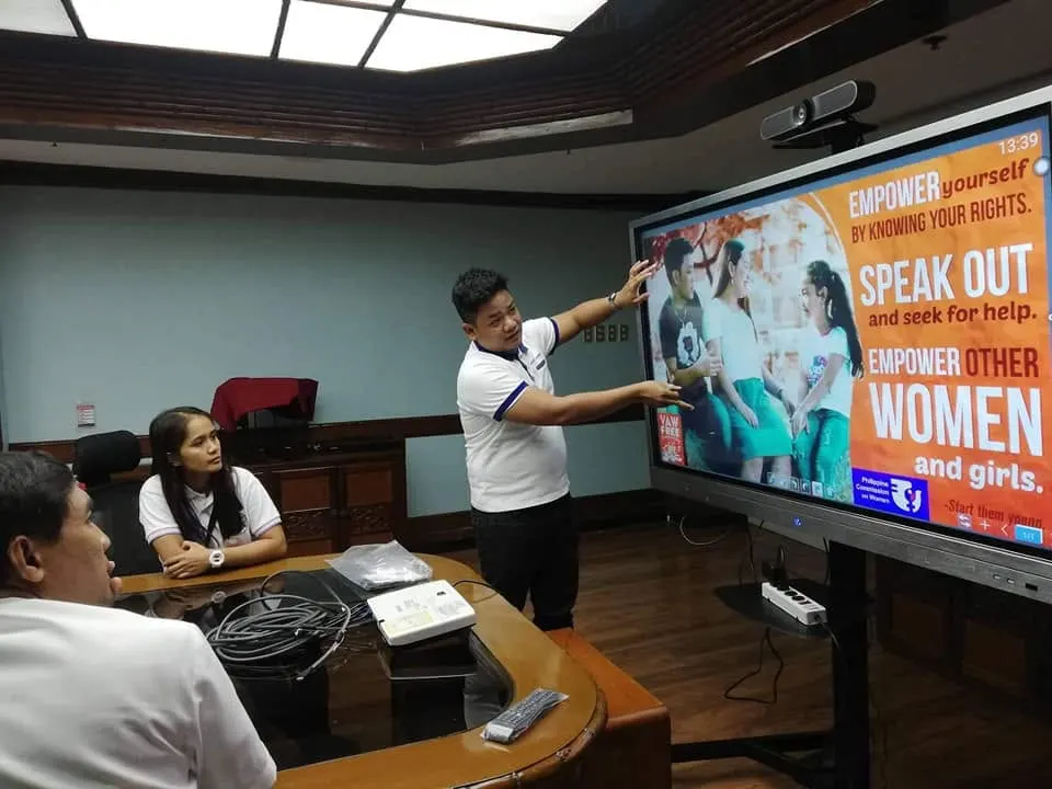 Wattsavers staff demonstrating a system on an interactive display